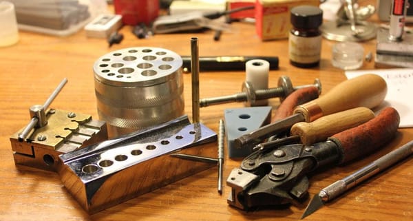 Photo of various pen repair tools on a wooden desk.